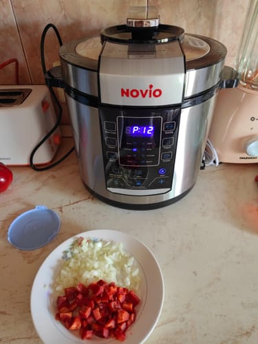 Customer's Novio SteelCook multicooker on a kitchen counter with a plate of chopped vegetables in the foreground.