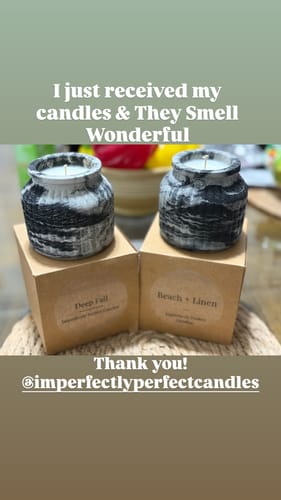 Customer's two Eclipse Noir candles with textured black and white marble-style jars sitting on top of their boxes.