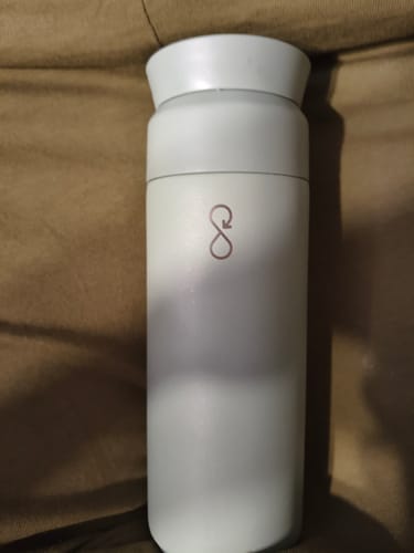 Customer's white insulated coffee travel cup with an infinity symbol logo.