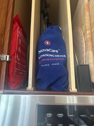 Customer's blue NovaCare anti-choking device stored inside a kitchen cupboard cabinet