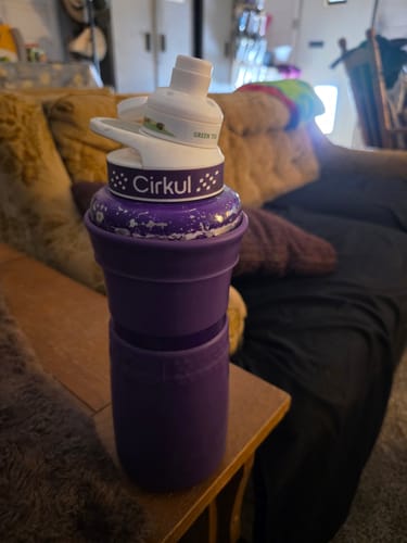 Customer's purple Cirkul water bottle with a sip cartridge attached, sitting on a side table.
