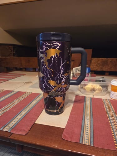 Customer's Thicc Buddy mug in dark purple with gold lightning and dragon patterns, sitting on a wooden table.