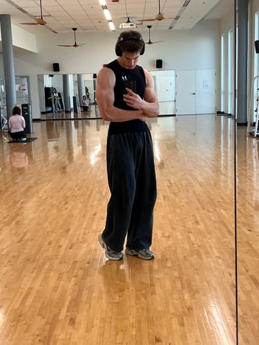 Customer's Demon Slayer baggy sweatpants worn by a tall person in a gym mirror selfie.