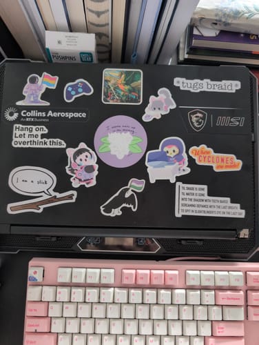Customer's Birb's Eye View Sticker Pack, shown as multiple colorful stickers applied to a black laptop lid.