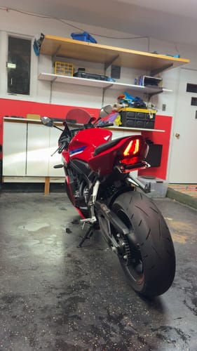 Customer's red Honda CBR650R parked in a garage, showcasing the installed tail tidy with illuminated rear light.