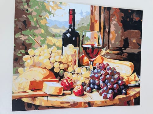 Customer's completed Vintage Vignette paint-by-numbers portrait of wine, cheese, and grapes on a table.