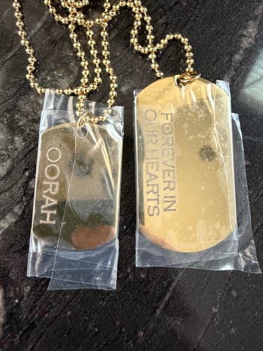 Reviewer's gold Double Dog Tag necklace, each tag protected in clear plastic sleeves, one engraved with OORAH.