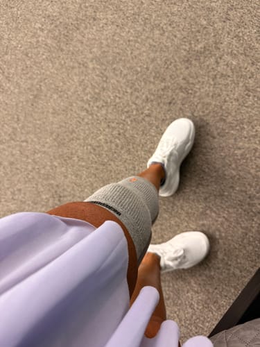 Customer's white CUURT Muuv court shoes worn while standing on a carpeted floor.