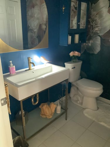 Reviewer's small Glow Bird light on a modern bathroom vanity counter.