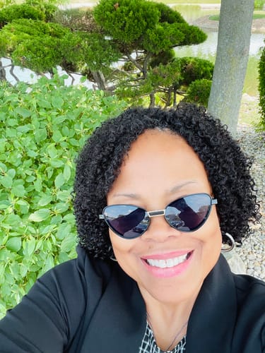 Customer's Multi-Textured Kinky Curly Crochet Hair in a short, natural black curly style outdoors.