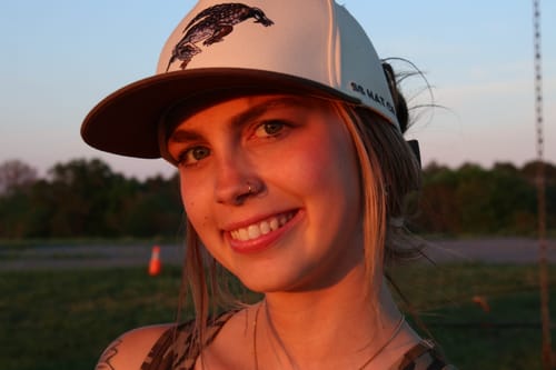 Customer's Hat of the Month Crew cap with a detailed animal patch, worn outdoors at sunset.