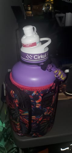 Customer's purple Cirkul water bottle inside a patterned floral sleeve, sitting on a table.