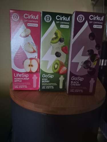 Customer's Kiwi Berry GoSip cartridge box standing next to other Cirkul beverage flavor boxes on a wooden surface.