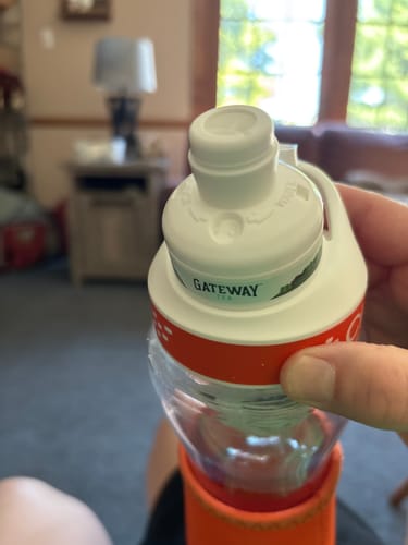 Reviewer holding a white and orange Gateway Tea bottle featuring a filter cartridge in the cap.