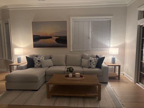 Customer's Tidal Whispers Canvas Art hanging on a wall above a living room sofa.