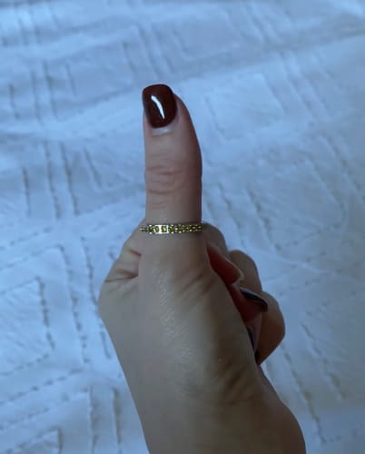 Customer's Eterna Birthstone Ring worn on a thumb, featuring small yellow gems in a thin band.