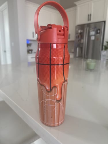 Customer's orange and tan Bottle Buddy basketball water bottle sitting on a kitchen counter.