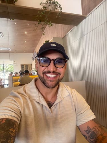 Customer's Óculos de Sol Jurerê com armação escura sendo usado por uma pessoa em ambiente interno.