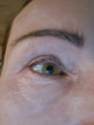 Reviewer's eye wearing an Opticcolors Allure lens, shown in a blurry, close-up shot.