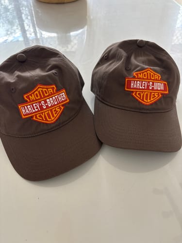 Customer's two brown Custom Canvas Caps with custom embroidered Harley-themed patches on a white surface.