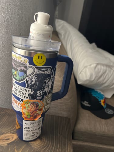 Customer's LifeSip Honeycrisp Apple pod placed in a dark blue covered cup with many stickers.
