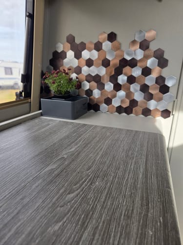 Customer's bronse selvklebende veggfliser montert i et sekskantet mønster på veggen i en bobil.