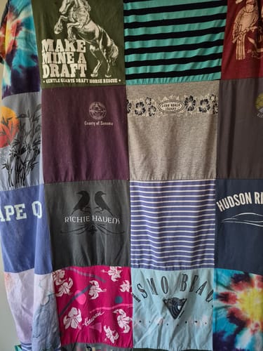 Customer's Project Repat T-Shirt Quilt made of colorful, patterned shirt patches featuring diverse graphics and text.