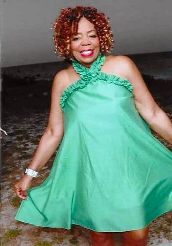 Reviewer wearing a green halter-neck midi dress with a simple, loose A-line silhouette.
