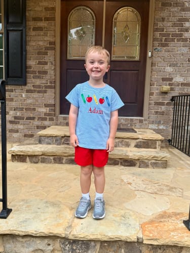 Customer's School Time Blue Stripe Short Sleeve Shirt with crayon and apple appliques, worn with red shorts.