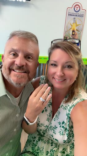 Customer's Silicone Ring on their finger, showing the oval-cut stone and flexible band while smiling with another person.