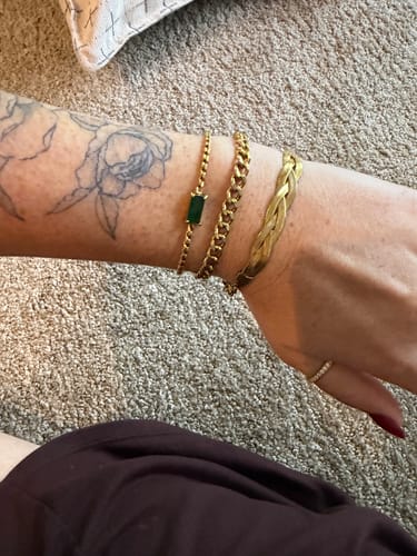 Customer's gold Castellanos Bracelet stacked with other jewelry on their wrist.