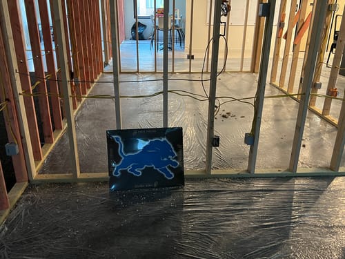 Customer's blue Detroit Lions 3D vintage wall art placed on the floor of a construction site for a new office.