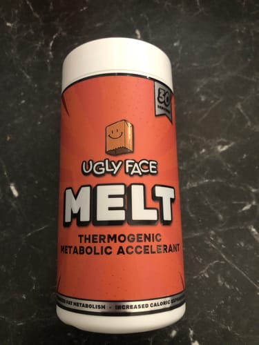 Customer's UGLYFACE MELT supplement container, featuring an orange label with a paper bag logo on a dark surface.