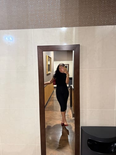 Customer's black Naked Sleeveless Capri Jumpsuit shown in a full-length mirror reflection.