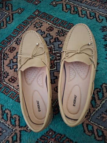 Customer's pair of beige EVERAU Summer Moccasin Frida shoes with bow detail, shown from above on a patterned rug.