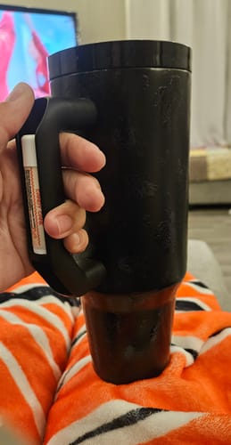 Customer's black floral Thicc Buddy mug held in hand, showing the chapstick holder on the handle.