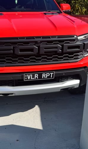 Customer's Slimline number plate bracket installed on the front bumper of a red truck