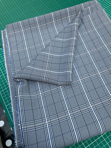 Reviewer's Blue Checkered Stretch Suiting Fabric, folded and draped on a green cutting mat.
