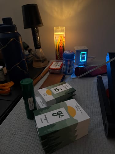 Customer's The Pre Roll Party Pack boxes and a single green container on a table with household items