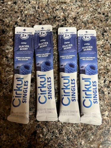 Customer's four blue Cirkul Singles FitSip Glacier Berry electrolyte drink mix sticks on a granite surface.