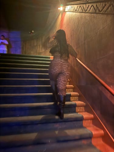 Customer's animal print Naked Print Closed Toe Jumpsuit worn while walking up stairs indoors.