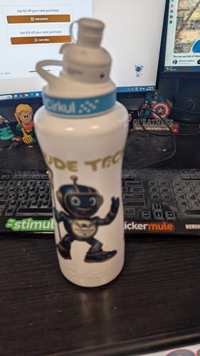 Customer's white Cirkul stainless steel bottle with a graphic, sitting on a desk in front of a keyboard.
