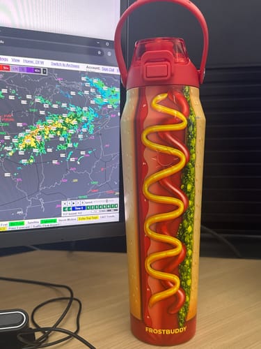 Customer's Bottle Buddy Big Dawg bottle with a hot dog pattern, sitting on a desk next to a computer monitor.