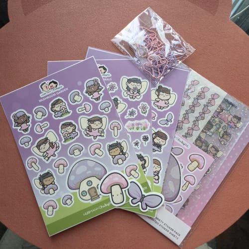 Customer's Sticker Subscription sheets featuring cute fairy and mushroom illustrations with pink heart-shaped clips.