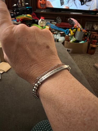 Customer's hand wearing the metallic IT'S A GOOD DAY TO HAVE A GOOD DAY bracelet.