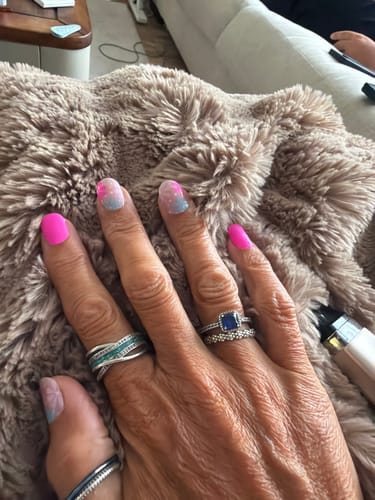 Customer's hand showing long, manicured nails with bright pink and glitter polish applied from Holy Gels Starter Kit.