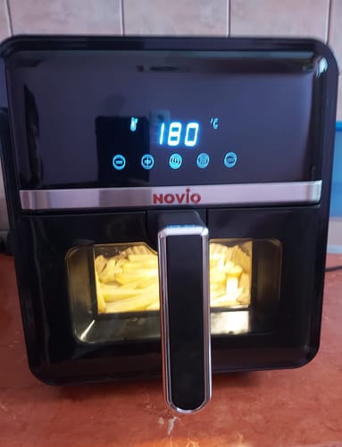 Customer's Novio StonePro air fryer on a kitchen counter, displaying 180 degrees Celsius and cooking potato fries inside.