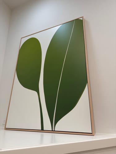 Reviewer's Verdant Duo abstract canvas art showing green leaves in a wooden frame on a white wall.