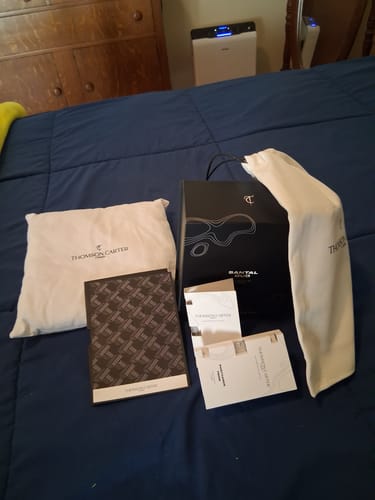 Customer's Santal Oud packaging and branded items displayed on a dark blue bedspread