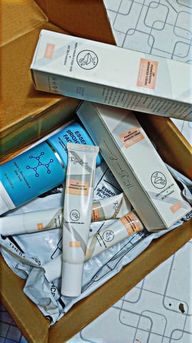 Customer's unboxed pack of two lip creams and a bright blue facewash, arranged with their product packaging.